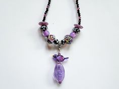 "I used beautiful lampwork beads made by Christina Burkhart, dichroic beads made by another lampwork artist and made a pendant using one of Erin Morris' bird bead. The necklace is strung with faceted black spinel beads and purple crystal beads as spacers. The necklace is 18.5\" long and the pendant is 2\". All metal components, including the lobster claw clasp is in sterling silver. As with most of my necklaces, I can add a sterling silver extension chain, if requested. Very sparkly, beautiful n Purple Beaded Necklace With Black Beads For Gift, Purple Necklace With Black Beads For Gift, Purple Necklace With Black Beads, Gift Purple Necklace With Black Beads, Adjustable Purple Necklace With Black Beads, Butterfly Beads, Lampwork Necklace, Beautiful Neck, Bird Beads