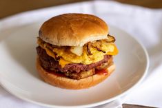 a hamburger with cheese and meat on a white plate