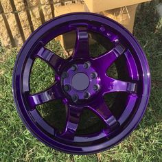 a purple wheel is sitting in the grass