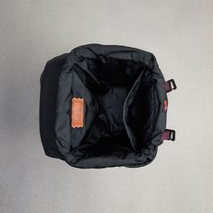 an empty black bag sitting on top of a gray floor