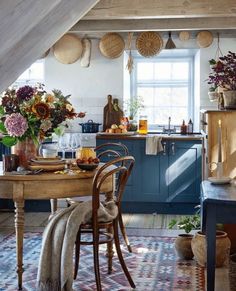 the kitchen is decorated in blue and white with lots of hanging baskets on the ceiling