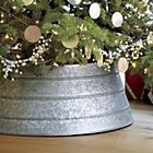 a christmas tree in a silver bucket on a table