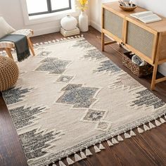 a living room area with a rug, chair and side table on the hardwood floor