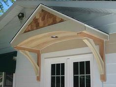 a white door with a wooden roof over it