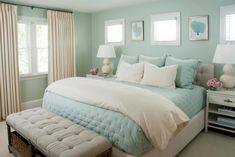 a bedroom with blue walls and white bedding