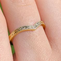 a close up of a person's hand with a wedding ring on their finger