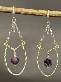 Artisan designed and handcrafted one of kind dangling chandelier earrings. The faceted 10 mm Amethyst, and rectangle Pink Amethyst both are dangling from the Sterling Silver Twisted Hoop.  These earrings are amazing with a dangle just under the earring lever back earring wire, and the focal bead is a brilliant deep purple amethyst bead. Total measurement length 3 1/4 inches long and width 1 inch wide including sterling silver leverbacks earring wire. Dangling Chandelier, Hoop Chandelier, Wire Craft, Earring Wire, Ear Rings, Amethyst Beads, Pink Amethyst, Artisan Design, Design Jewelry