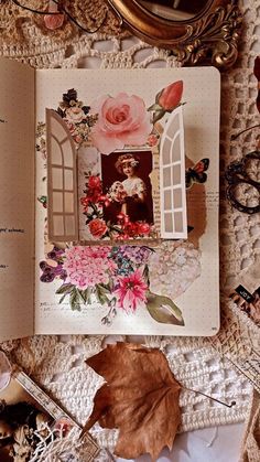 an open book with pictures and flowers on the pages next to a mirror, eyeglasses, and other items