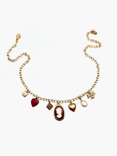 This charm necklace is the perfect mix of classic and trendy... made of mostly vintage charms on a vintage gold-plated chain, we can't even pick our favorite charm! 7 charms hang from this 18" vintage oval-cable chain: tiny brass cat face vintage powder-coated red heart vintage brass dice charm vintage glass/ gold plated cameo charm vintage brass puffy heart clear, natural quartz tear-drop shaped pendant, vermeil (18K gold plated) vintage brass bow Details: 18" in length, but can be clipped to w Cheap Vintage Heart Charm Jewelry, Vintage Charm Necklace With Heart Pendant, Luxury Oval Necklace With Vintage Charm, Luxury Vintage Charm Necklaces, Luxury Vintage Charm Round Necklaces, Elegant Heart-shaped Charm Necklace With Vintage Charm, Heart-shaped Vintage Charm Necklaces, Vintage Heart-shaped Necklace With Vintage Charm, Brass Bow