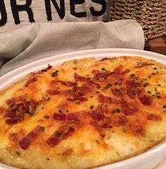 a close up of a casserole on a plate near a basket and napkin