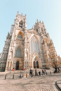 people are standing in front of an old cathedral