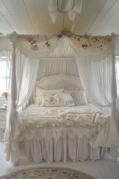 a white bed sitting inside of a bedroom next to two windows