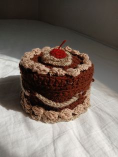 a crocheted cake sitting on top of a white sheet