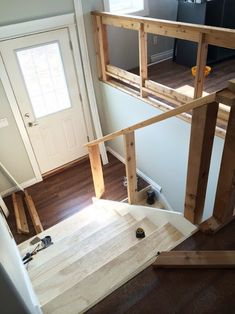 an overhead view of a house with wood flooring and white walls, stairs leading up to the front door