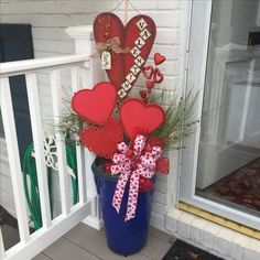 a blue bucket filled with red hearts on top of a porch