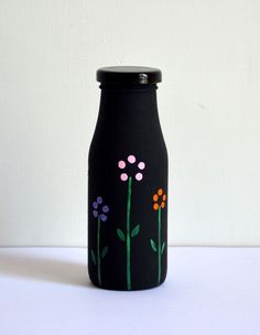 a black vase with flowers painted on it