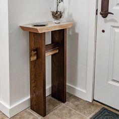 a small wooden table with a vase on top