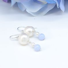 "Blue and white! Beautiful fresh colours. Large 10mm white round pearl with striations, 2mm white seed pearl, and beautiful blue 6mm round lace agate. Simple, delicate. From the pierce it is 1.5\" with a 1\" drop." White Pearl Pendant Earrings In Sterling Silver, Elegant Light Blue Pearl Jewelry, Blue Round Pearl Earrings For Anniversary, Elegant White Round Bead Earrings, Blue Teardrop Pearl Drop Earrings, Classic Blue Round Pearl Earrings, Blue Pearl Earrings With Pearl Charm, Blue Drop Pearl Earrings With Pearl Charm, Blue Pearl Charm Earrings As Gift