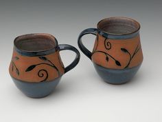 two brown and blue mugs sitting next to each other