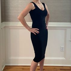 a woman in a black dress posing for the camera with her hands on her hips