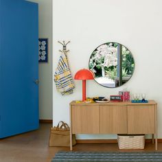 there is a blue door and a mirror on the wall in this room with furniture