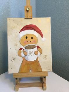 a painting of a ginger holding a coffee cup on a wooden easel with snowflakes around it