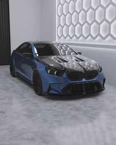 a blue sports car parked in front of a white wall with geometric designs on it