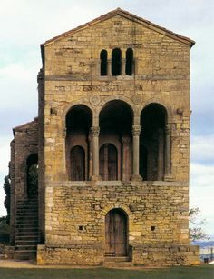 an old stone building with arched doorways and steps leading up to the top floor