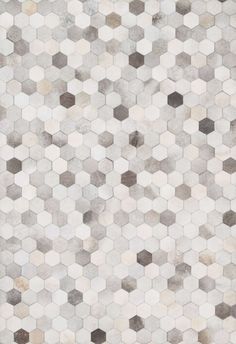 an area rug with hexagonal shapes in grey, white and beige colors on the floor