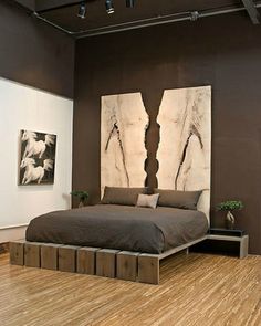 a large bed sitting in a bedroom next to a painting on the wall above it