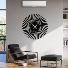 a living room with a clock on the wall next to a black chair and ottoman