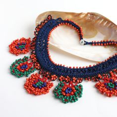 the beaded necklace is next to a shell