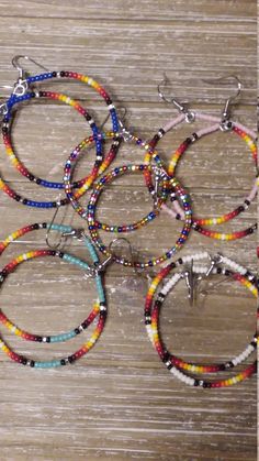 Native American seed bead hoop earrings. The multi colored random mix hoops are 2 1/4 inches in length including earwire. The blue, pink, turquoise, and white with the ombre pattern are 2 1/2 inches in length including earwire. All have surgical steel earwires. Multicolor Hoop Earrings With Ear Wire, Handmade Multicolor Heishi Beads Hoop Earrings, Handmade Multicolor Hoop Earrings With Heishi Beads, Multicolor Heishi Beads Jewelry With Dangling Beads, Multicolor Small Hoop Jewelry With Spacer Beads, Multicolor Hoop Earrings With Round Beads, Multicolor Hoop Beaded Earrings With Spacer Beads, Multicolor Beaded Hoop Earrings With Spacer Beads, Multicolor Circular Beaded Earrings With Ear Wire