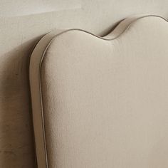 an upholstered headboard on the back of a bed with no sheets or pillows