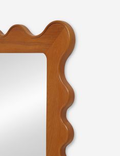 a wooden frame mirror with scalloped edges