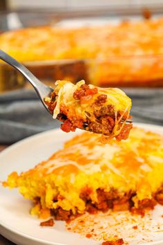 a piece of lasagna being lifted from a white plate with a serving spoon