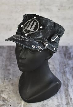 a mannequin head wearing a black leather hat