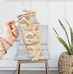 a person is holding a cup in front of a chair with a plant and potted cacti