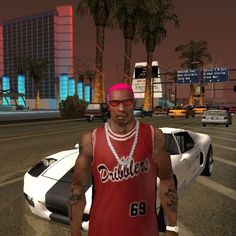 a man in a red shirt and sunglasses standing next to a white car on a city street