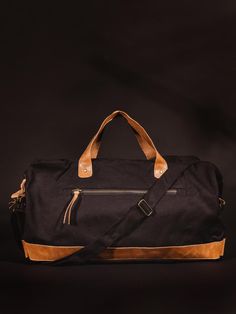 Black colored handcrafted canvas duffle bag with leather straps on black studio background. Canvas Weekender Bag, Canvas Satchel, Trip To Paris, Weekend Bag, Long Trips, Phone Pouch, Long Weekend, Tan Color, Vegetable Tanned Leather