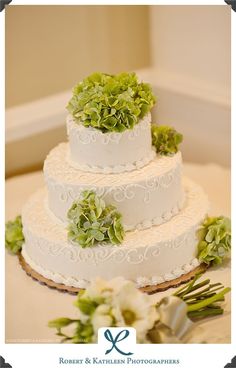 three tiered wedding cake with green flowers on top