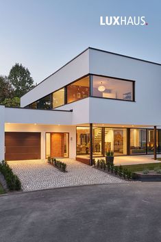 a large white house with lots of windows on it's sides and an open driveway