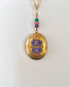 "New Old Stock ~ Like new condition. This vintage oval locket has a beautiful heavy gold plate and is hand enameled. Pretty complimentary Czech glass beads and glass crystal accent the colors of the enamel. The locket opens and closes securely to hold a treasured picture or small object. It measures 3/4\" wide and 1\" long and hangs from a gold plated 14K 16 inch signed Lucy Isaacs chain. Thank you for visiting Lucy Isaacs Jewelry here at our online store. To view all of my vintage Czech glass i Oval Enamel Locket Jewelry, Oval Enamel Locket Necklace, Oval Locket Necklace In Enamel, Gold Oval Enamel Jewelry, Oval Gold Enamel Jewelry, Gold Enamel Locket Jewelry, Gold Enamel Jewelry With Locket, Vintage Enamel Oval Pendant Jewelry, Antique Oval Enamel Necklaces