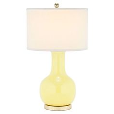 a yellow table lamp with a white shade