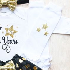 "This is an adorable New Year's outfit. This outfit features a bodysuit with the words \"My First New Years\" The outfit is complete with a matching black head and black/gold tutu. Other options to complete the outfit are a matching black headband/tutu and white leggings with gold stars on them. Other bottoms/headbands are available in the shop as well. HOW TO ORDER: 1.Bodysuit-Select Style and Size from the drop down and add to cart (S/S=Short Sleeve, L/S=Long Sleeve). 2.Add bottom and headband Party Outfit Black, New Year's Outfit, Gold Tutu, Outfit Holiday, Outfit Photo, Black Tutu, Bodysuit Designs, New Years Outfit, Sequin Bow