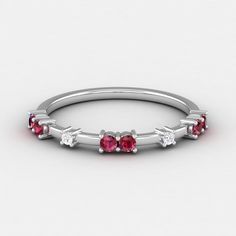 a white gold ring with three ruby stones on the side and four diamonds in the middle