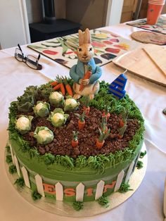 a cake with carrots and plants on it