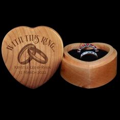 a wooden ring box with an engraved wedding ring inside and in it's lid