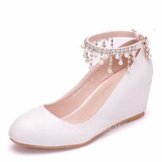 a pair of white wedges with pearls on the heel and ankle strap are shown