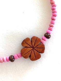 Darling little hand carved genuine Hawaiian Koa wood flower beaded with tiny dust rose pink vintage African glass beads and .925 sterling silver clasp. Koa wood plumeria flower is 1/2inch and beaded with 3-4mm vintage African trade beads in sweet dusty pink color. Necklace is 15 1/2 inches plus 2 Inch extension. Spring ring clasp and all findings are .925 sterling silver. Choker also available in aqua, orange and yellow. Pink Flower Beaded Necklaces For Beach, Pink Flower Beaded Necklaces For The Beach, Adjustable Pink Flower Necklace, Pink Handmade Adjustable Flower Necklace, Handmade Adjustable Pink Flower Necklace, Pink Wooden Beads Necklace For Gift, Adjustable Pink Flower Necklace With Round Beads, Pink Wooden Beaded Necklaces For Gifts, Adjustable Flower Necklace